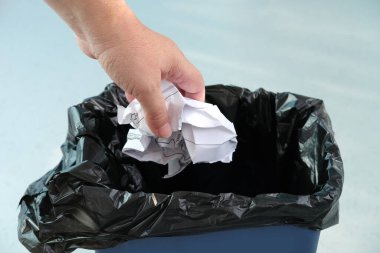 Kadın, kırışık kağıdı geri dönüşüm kutusuna, yakın çekim ellerine, ev atığı öğütme konseptine, farklı çöp kutularına, atık geri dönüşümüne, yeniden kullanımına, belgelerin yok edilmesine koyar.