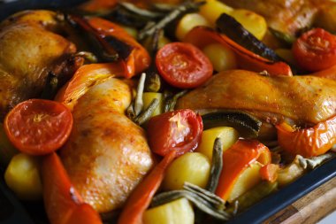 Lezzetli köri soslu fırında tavuk budu, etli fırında patates, kırmızı biber, yeşil biber, olgun domates, baharat, abur cubur konsepti, geleneksel aile partisi.