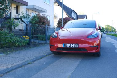 kırmızı Tesla modeli Y caddeye park edilmiş, Amerikan Elon Musk şirketinden popüler elektrikli araç, konsept çevre minimize etme, High Tech Technology, alternatif enerji, Frankfurt - Mayıs 2023