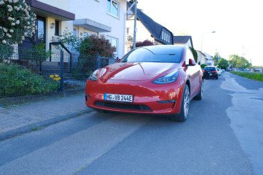 kırmızı Tesla araba modeli Y caddeye park edilmiş, Amerikan Elon Musk şirketinden elektrikli yolcu aracı, konsept çevre minimize etme, High Tech Technology, alternatif enerji, Frankfurt - Mayıs 2023