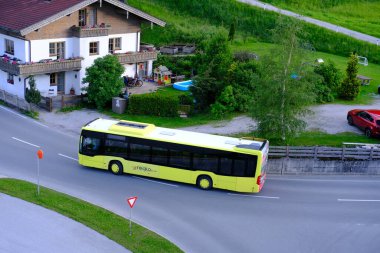 yellow Tyrol public transport buses, roads in valley of mountain villages near Achensee lake in Austria, concept of transportation, tourism, active lifestyle, Pertisau, Austria - June 2022