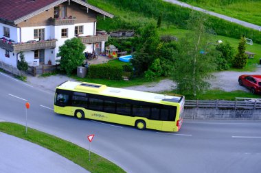 yellow Tyrol public transport buses, roads in valley of mountain villages near Achensee lake in Austria, concept of transportation, tourism, active lifestyle, Pertisau, Austria - June 2022 clipart