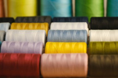 Pembe, turuncu, sarı, kırmızı, kahverengi, yeşil, mavi, eflatun, beyaz iplik makaraların üzerinde, doğal, yapay lifler endüstride, el yapımı, ev yapımı dikişler için,