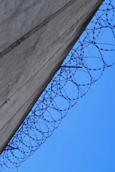 Ψηλό Τσιμεντένιο Φράχτη Συρματόπλεγμα Στην Κορυφή Προδικαστικό Κελί Κράτησης Κτίριο — Φωτογραφία Αρχείου