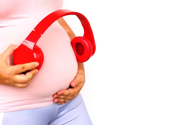 Middle Aged Pregnant Woman Pink Shirt Holds Headphones Her Belly — Fotografie, imagine de stoc