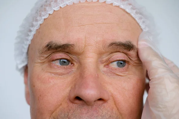 成熟男性脸 65岁男子 美容师 美容师检查皱纹 与年龄有关的变化概念 美学注射美容术 护理抗衰老程序 — 图库照片