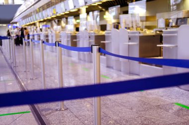Genel olarak Frankfurt am Ana Havalimanı 'nın büyük, parlak salonu, yolcu giriş terminali, doğrudan bagaj kontrolüne bağlı mavi kurdeleler, uçuş kartları, uçak yolculuğu konsepti.