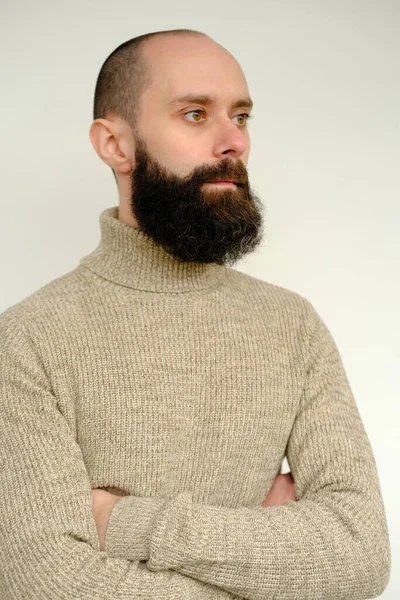 近视的男性面孔 年轻的有胡子且有胡须的男人 满意的男人 30年来穿着米色羊毛衫 严肃地将目光移开 人类健康的概念 对生命意义的反思 — 图库照片