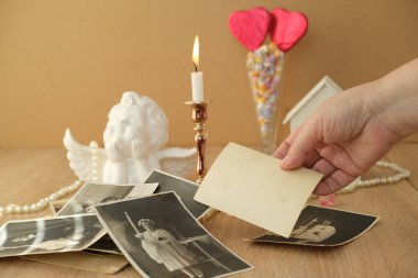 Yakın plan kadın eli, eski vintage fotoğraflar, aşk tarzında romantik hayat, çubuklarda kırmızı kalpler, mumların yanması, aşk tanrısı, aile ağacı konsepti, soy ağacı, çocukluk anıları.
