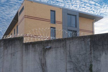 Dikenli teller, yüksek beton çitler, dikenli teller, suçlulara verilen cezaların infazı için bina, konsept hapishane, güvenlik bölgesi, esaretin sembolü, umutsuzluğun esareti.
