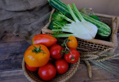 Sepetteki olgun sebzeler, domatesler, salatalıklar, kabak, kereviz, geçmişe dayalı tahıl, çuval bezi, hasat konsepti, sağlıklı gıda malzemeleri, çiğ gıda ve vejetaryenlik için yiyecek.