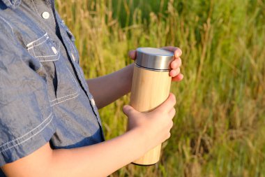 Çocuk, çocuk 8-10 yaşlarında. Bir şişe su, ahşap termos, konsept vücut suyu, fitness ekipmanları, aktif yaşam tarzı, egzersiz motivasyonu, sağlık ve sağlık.