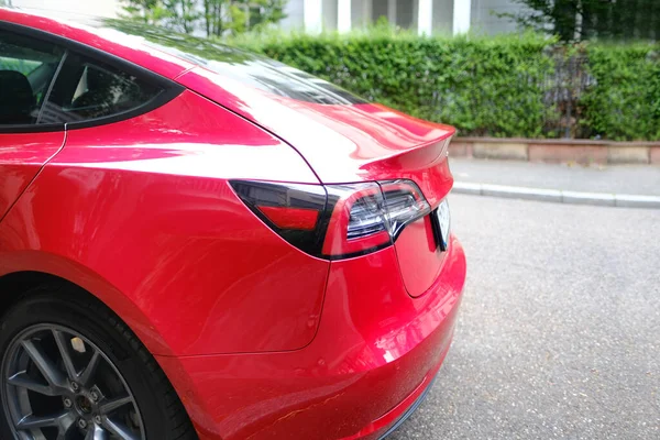 路上に停められた赤い電気自動車の一部 テールライト全電気セダン コンセプト環境最小化 ハイテク技術 — ストック写真