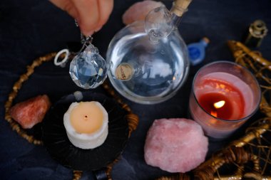 Kadın falcının el ele tutuşması ve cam küre kristali kullanması, sarkacın masanın üzerinde sallanması, meditasyon, kendini keşfetme, ruhsal enerji ve denge, kehanet ve fal bakımı.