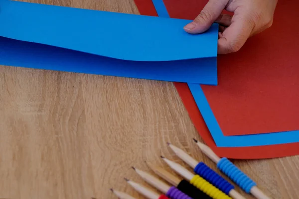 特写妇女手里拿着一张蓝色的纸 剪贴材料 针线活的概念 手工制造和手工创作 — 图库照片