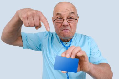 Çılgın doktor, elinde boş mavi kart var. Yüzünde anlamlı ifadeler olan yaşlı bir doktor. Saldırgan bir şekilde boş maket gösteriyor.