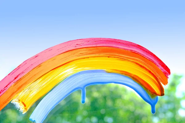 Stock image painting rainbow on glass, rain outside window, paints symbol many meanings, gouache, acrylic, creative development, texture background with water drops, place for text, blurry banner, happy childhood