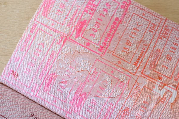 close up part of pages of foreign passport with foreign visas, border stamps, permits to enter countries, concept of traveling around the world, traveler\'s travel document