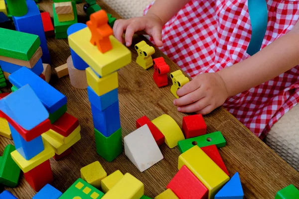 girl plays role-playing games with wooden figurines, figures, blocks, kindergarten games, concept of childhood, earlier child development, creativity, early training