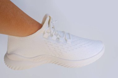 Yeni beyaz yürüyüş ayakkabıları tutan kadınların elleri, bağcıklı hafif arka plan, konsept Ayakkabı Bakım ve Bakım, Spor, Aktif Yaşam tarzı, Ayakkabı Mağazası veya Perakende