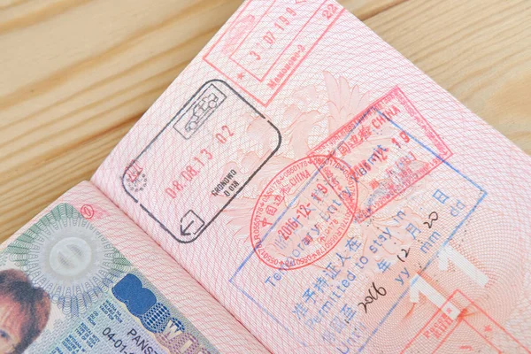 用外国签证 中国的边境印章 入境许可 环球旅行的概念 旅行者的旅行证件将部分外国护照页合上 — 图库照片