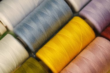 Pembe, turuncu, sarı, kırmızı, kahverengi, yeşil, mavi, eflatun, beyaz iplik makaraların üzerinde, doğal, yapay lifler endüstride, el yapımı, ev yapımı dikişler için,