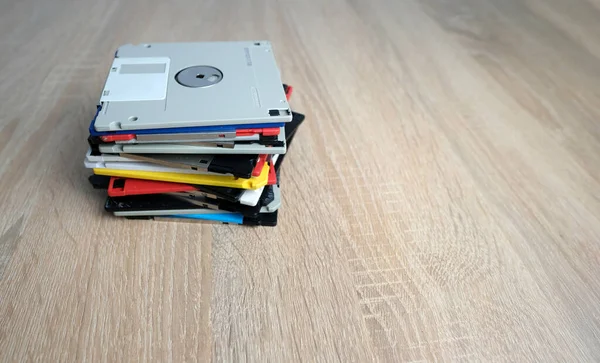 老式复古电子数据存储设备 从80年代到90年代的闪存器散落在桌上 成堆的软盘 笔盘和硬盘驱动器 有灰色 — 图库照片
