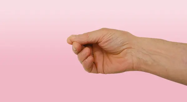 ジェスチャー指のホールディング インデックスと親指のピンチで大人の成熟した男性の男性の手のクローズアップ 何も保持 ショー ピンクの背景にプレス デザイナーのための無視言語の概念 — ストック写真