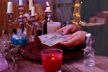 Librate with money, female hands of psychic doing witchcraft passes with dollars, esoteric Oracle performs ritual of removing spell of black magic, esoteric business, magic to increase income clipart