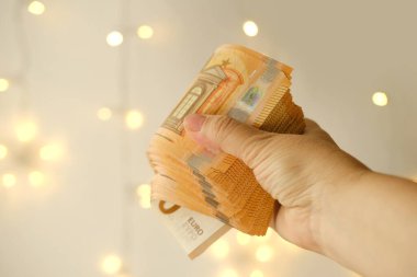 Kadın eli nakit 50 euro Bokeh ile güzel bulanık krema geçmişi, ödenek, tatil hediyesi, yoksullara sosyal yardım, tatil, araba, kumarhane kazançları için tasarruf