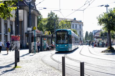 Şehir manzarası, istenen ulaşım güzergahı için tramvay bekleyen insanlar, Alman toplu taşıma sistemi, ulaşım altyapısı, Frankfurt - 10 Ağustos 2023