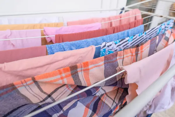 wet clothes of pink color hanging on clothes dryer, Laundry Routine and Household Chores, Efficient Management in home environment, lonely life
