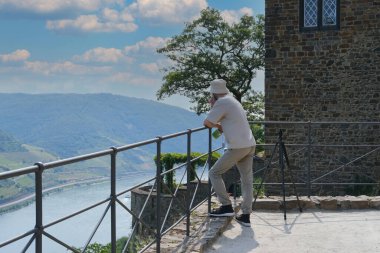 Sooneck Şatosu 'nun arka planına karşı genç bir adam, gözlem güvertesinde dinlenen bir turist, rotasında dinlenen, Ren ve Moselle' de romantik bir gezi konsepti