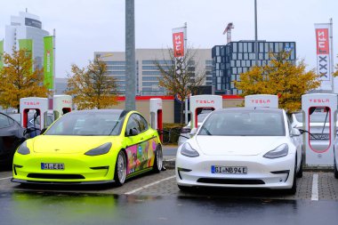 Frankfurt, Almanya, Ekim 2021: Birçok Tesla hafif elektrikli otomobil şarj istasyonunda pil dolduruyor, alternatif enerji geliştirme konsepti, elektrikli araç üretimi