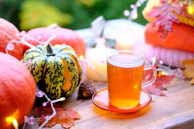 Yeşil çay bardağını kaplamalı, çay tabağının üstünde, ahşap masa üzerinde, balkabağı yalanı, mumlar yanıyor, sabah konsepti, mevsimlik sonbahar havası, sağlıklı yaşam tarzı.