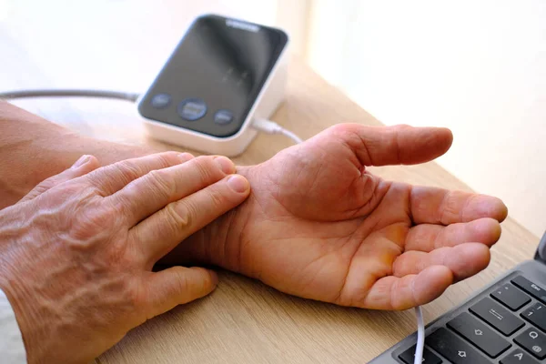 有特殊装置的男性手的血压测量 心血管健康监测 心率监测 高血压诊断 — 图库照片