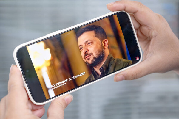 выступление Президента Украины Владимира Зеленского на экране мобильного телефона, новости о конфликте Украина и Россия, военные события, iPhone в женских руках, Франкфурт, Германия - 1 сентября 2023 года