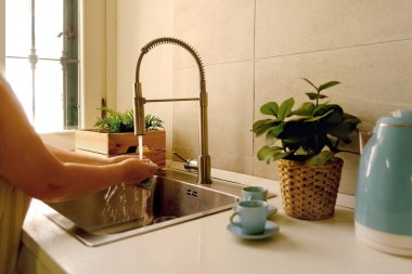 Ev hanımının elleri temizleme ve temizleme, bulaşıklar için çelik lavabo, modern krom musluk, Ev Temizliği rutini
