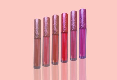 Arka planda sıvı parlak ruj tüpleri, kırmızı, ahududu, pembe, mercan, şeftali rengi yakın plan, dekoratif kozmetik konsepti, makyaj eğilimleri, kozmetik zarafet, güzellik endüstrisi