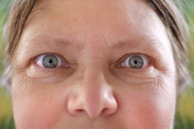 Olgun kadın yüzünün bir kısmını kapat, 50 yaşında bir kadın, insan gözü, yüz kırışıklıkları, cilt durumu, yaşla ilgili deri değişiklikleri, estetik enjeksiyon kozmetolojisi, yaşlanma önleyici bakım.