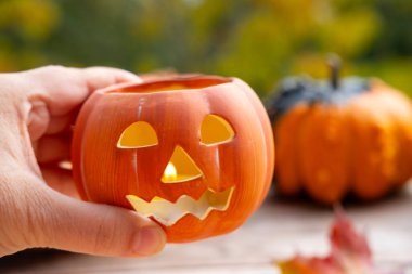 Balkabağı şamdanlı Jack, kadın elinde mum, sonbahar yaprakları, balkabakları, Cadılar Bayramı hazırlığı, balkabağı mum ışığı, sonbahar dekoru.