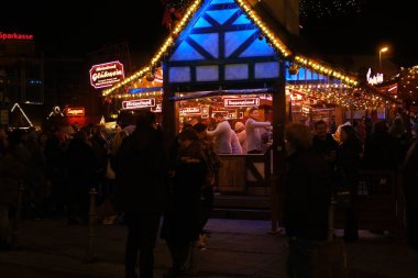 Sanatçılar şeker ve fast food satıyor, insanlar kış caddesi boyunca Noel pazarında yürüyor, akşam bulanık kış şehri manzarası, Noel şenlikli atmosferi, Frankfurt - 27 Aralık 2022