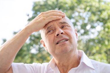 Adam 60 yaşında, kıdemli, şiddetli baş ağrısı, hafıza kaybı ve konsantrasyon kaybı, gergin, olgun erkek kafasına yakın çekim, yorgun, yorgun ve bitkin.