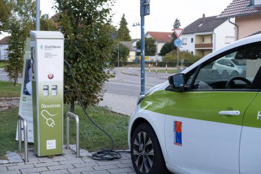 Yolcu elektrikli reno otomobil şarj istasyonunda pil dolduruyor, alternatif enerji geliştirme konsepti, elektrikli araç üretimi, Karlsdorf, Almanya - 15 Ekim 2023