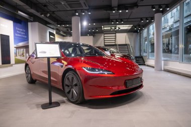 Showroom 'da yeni kırmızı Tesla Model 3 elektrikli araba, çağdaş Avrupa' da EV kullanımındaki trendler, otomotiv endüstrisindeki son teknolojiler, çevresel sürdürülebilir, Frankfurt - 9 Kasım 2023
