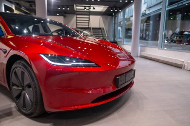 Showroom 'da yeni kırmızı Tesla Model 3 elektrikli araba, çağdaş Avrupa' da EV kullanımındaki trendler, otomotiv endüstrisindeki son teknolojiler, çevresel sürdürülebilir, Frankfurt - 9 Kasım 2023