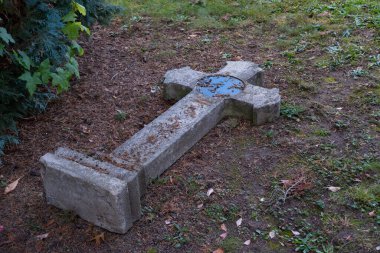 Eski ortaçağ mezarı yere düşmüş, cadılar bayramı konsepti, zaman geçmiş, hayatın sonu, mezarlıkta vandalizm, dini temellerin ayaklar altına alınması.,
