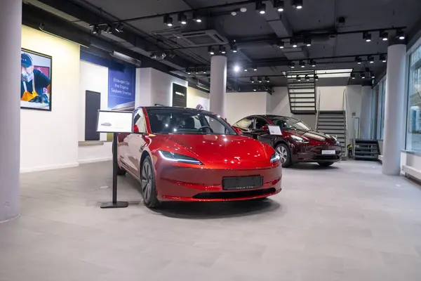 stock image new red Tesla Model 3 electric car in showroom, trends in use EV in contemporary Europe, latest technologies in automotive industry, environmentally sustainable, Frankfurt - November 9, 2023