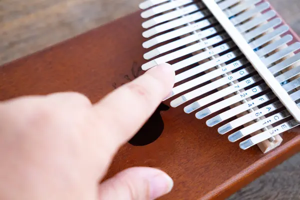 Female hand touches metal plates of kalimba, African percussion musical instrument class lamellaphones or plucked reed idiophones, Music therapy