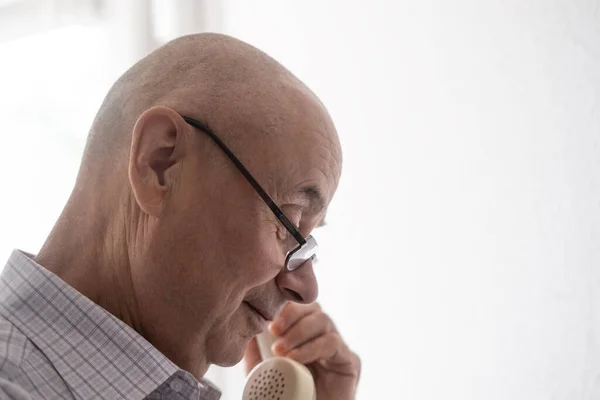 Mature man speaking on vintage telephone, hand removing Handset, white Rotary Telephone with Disc Dial, putting retro phone reciver down, hanging up, calls helpline, psychological support
